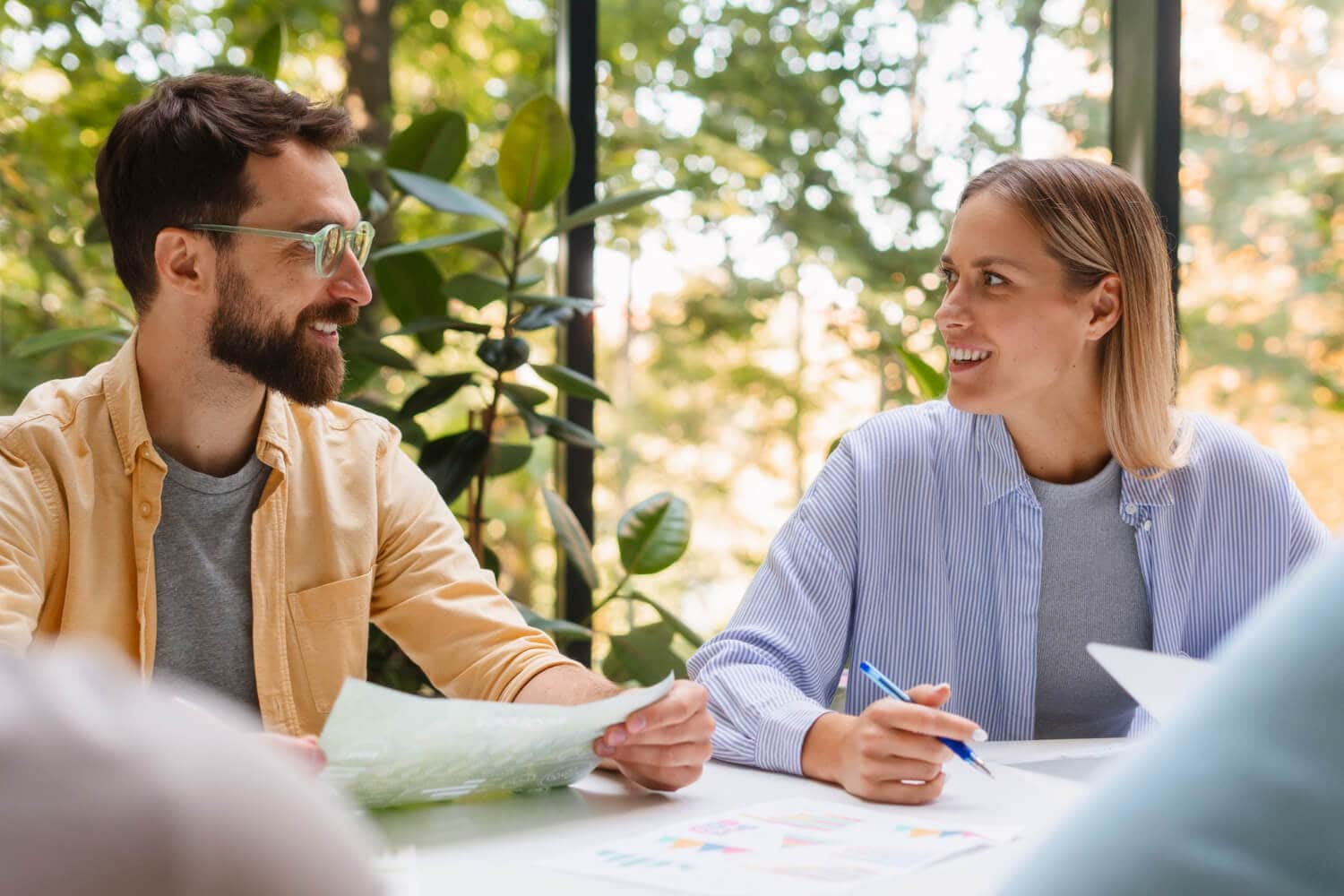 Spotkanie biznesowe – kobieta i mężczyzna omawiają projekt przy stole