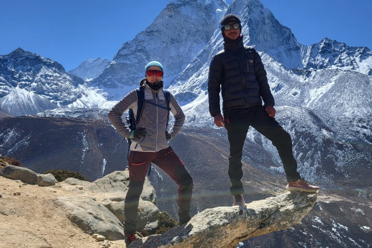 Trekking w Himalajach – dwoje uczestników na tle ośnieżonych szczytów Nepalu.
