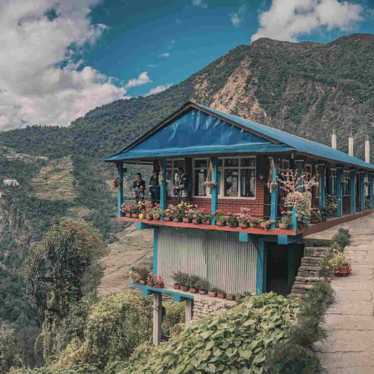 Malownicza lodge z niebieskim dachem w nepalskich Himalajach.