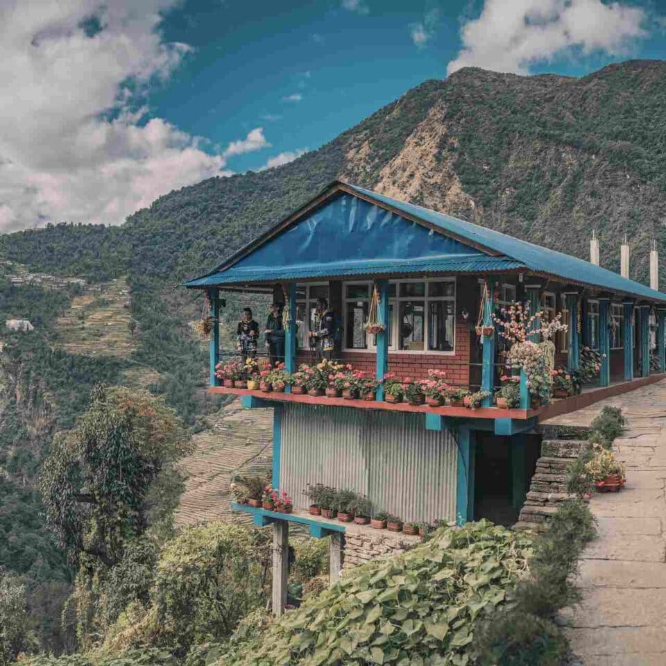 Malownicza lodge z niebieskim dachem w nepalskich Himalajach.