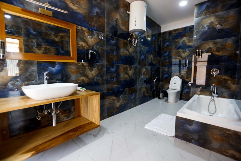 Nowoczesna łazienka z wanną, umywalką nablatową i stylowymi, ciemnymi kaflami z marmurkowym wzorem