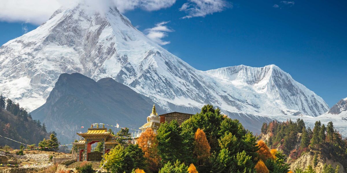 Malownicza wioska w Himalajach z widokiem na ośnieżony szczyt Manaslu – krajobraz Nepalu, klasztor buddyjski i jesienna roślinność