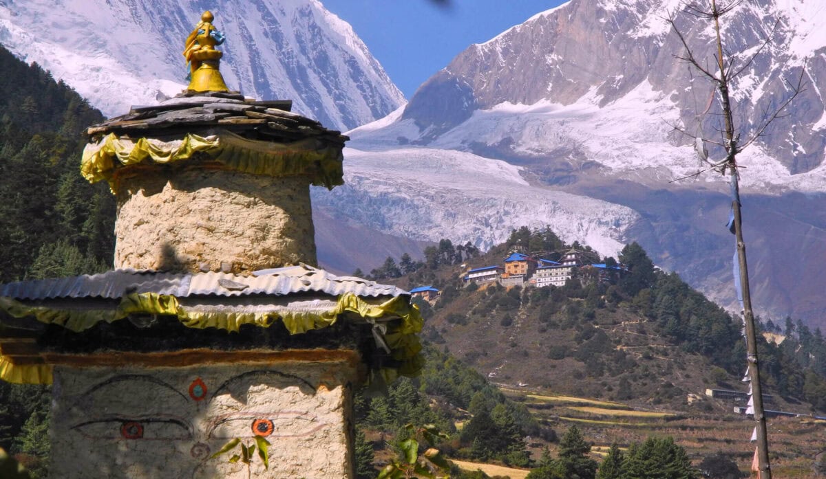 Stupa buddyjska na tle himalajskich szczytów w regionie Manaslu – tradycyjna architektura sakralna Nepalu z klasztorem w oddali