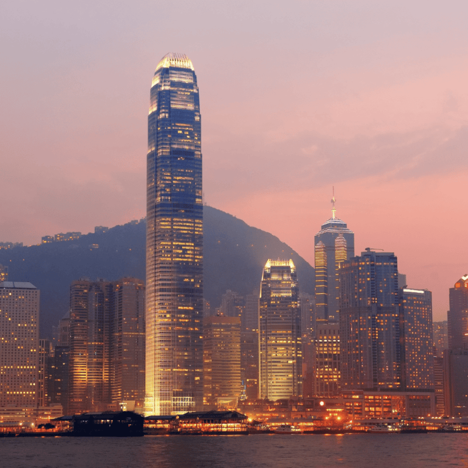 Panorama wieżowców Hongkongu o zmierzchu z IFC Tower na pierwszym planie i górą w tle.