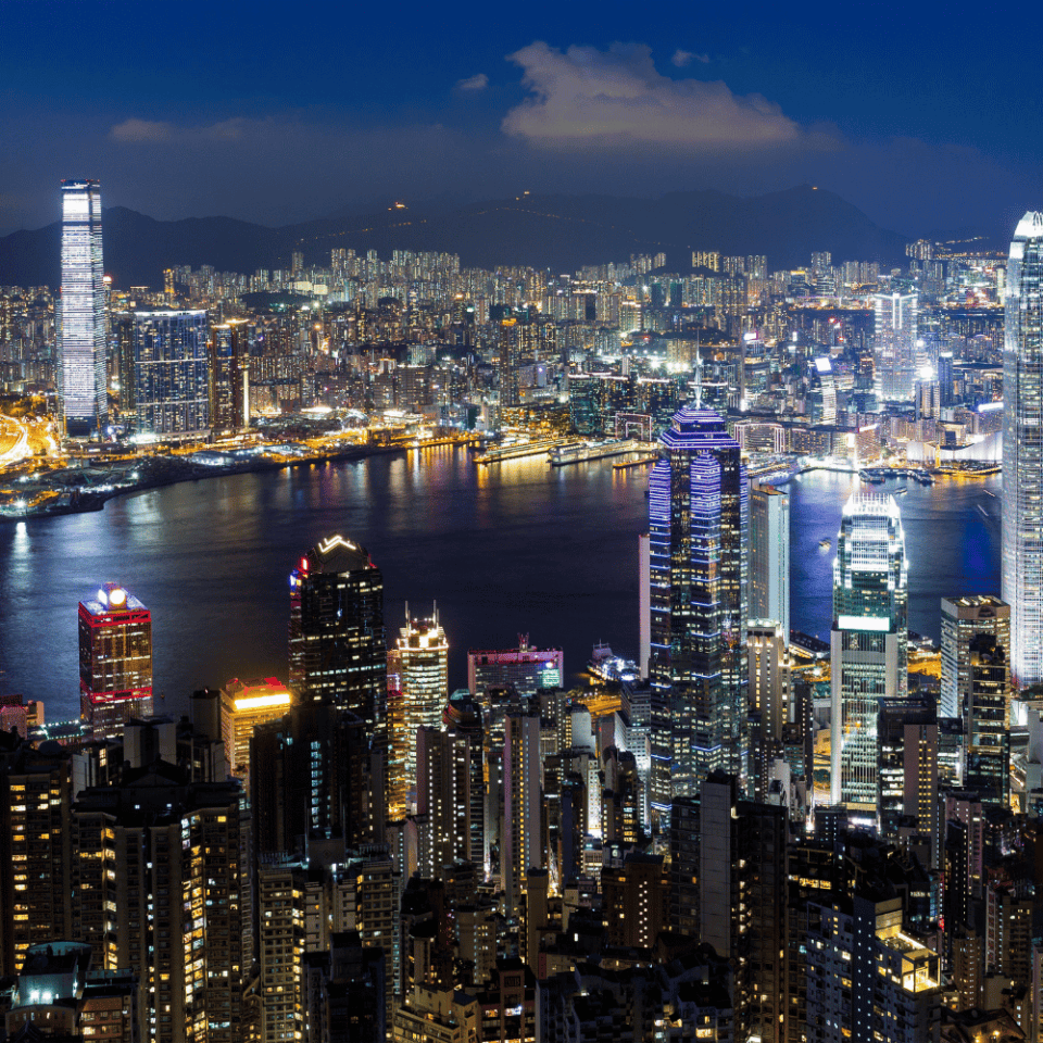 Nocny widok na Hongkong z podświetlonymi drapaczami chmur nad zatoką Victoria.