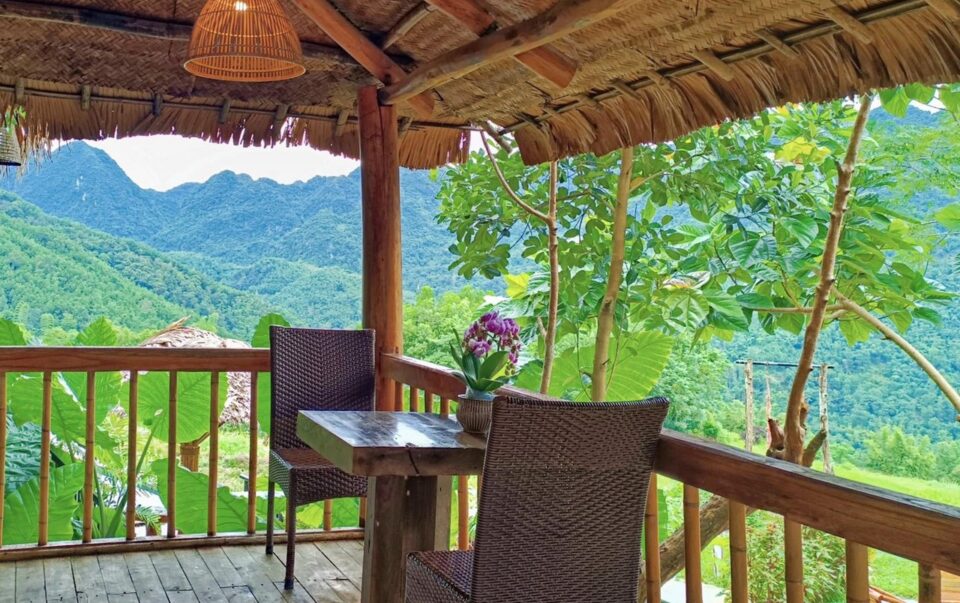 Taras bambusowej chatki z widokiem na g&oacute;ry i tropikalną zieleń w okolicy Pu Luong w Wietnamie.