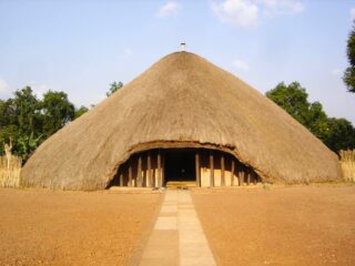 Budynek o wysokim, stożkowym dachu pokrytym strzechą – mauzoleum Kasubi Tombs w Kampali, Uganda.