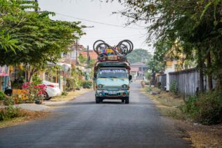 Bus serwisowy z rowerami na dachu, pełniący funkcję samochodu wsparcia podczas wyprawy rowerowej w Laosie.
