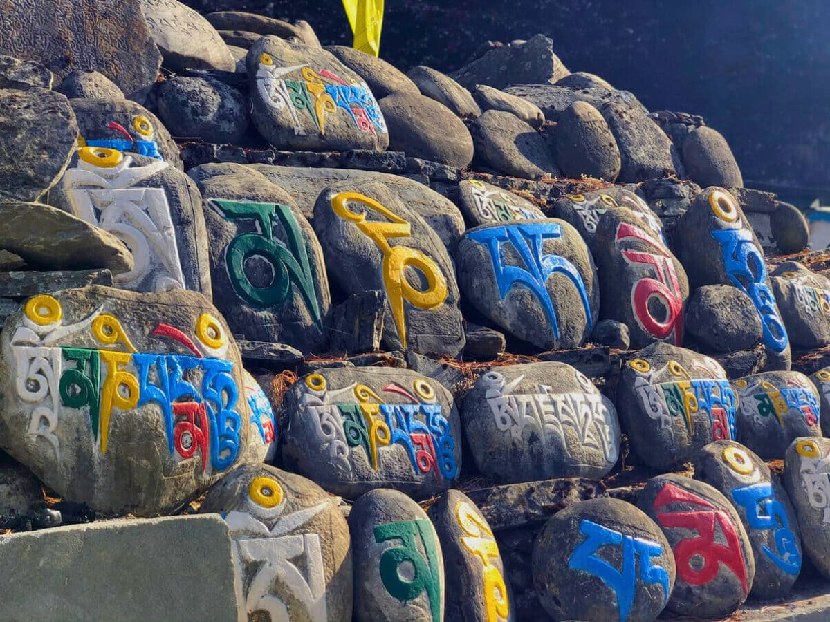Kolorowe kamienie modlitewne mani z buddyjskimi mantrami – tradycyjna kultura duchowa w Himalajach Nepalu, region Manaslu