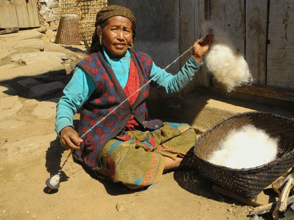 Nepalska kobieta przędząca wełnę tradycyjną metodą – rzemiosło i życie codzienne w Himalajach, kultura ludu Gurung, region Manaslu