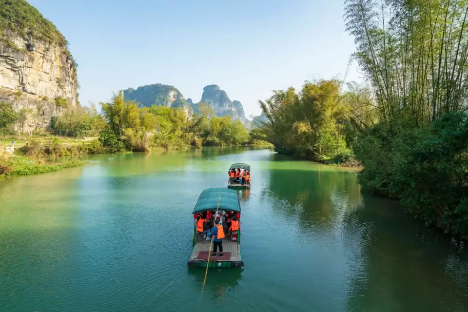 Turkusowa rzeka Yulong w Yangshuo z bambusowymi brzegami i górami krasowymi