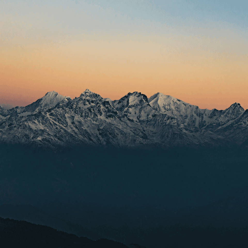 Spokojny widok na pasmo górskie w Parku Narodowym Langtang w Nepalu o wschodzie słońca, z wyraźnymi ośnieżonymi szczytami na horyzoncie.