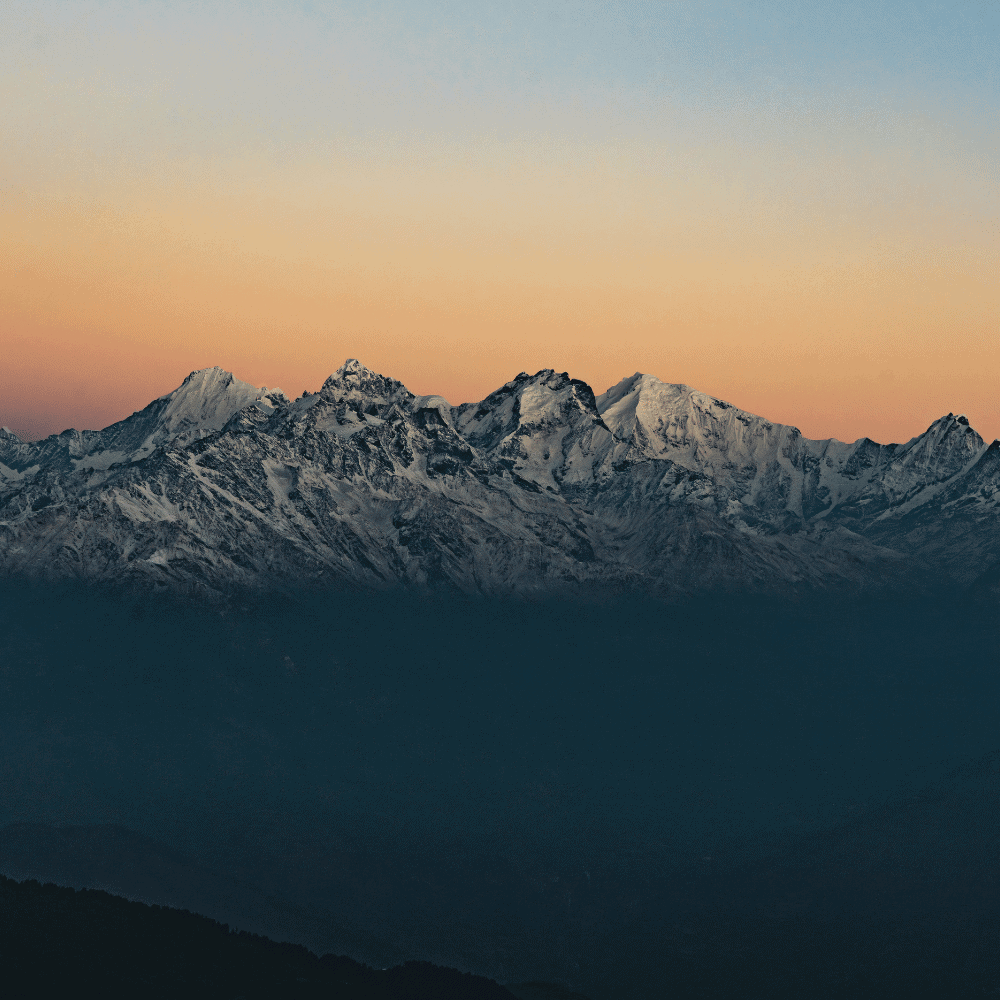 Spokojny widok na pasmo górskie w Parku Narodowym Langtang w Nepalu o wschodzie słońca, z wyraźnymi ośnieżonymi szczytami na horyzoncie.