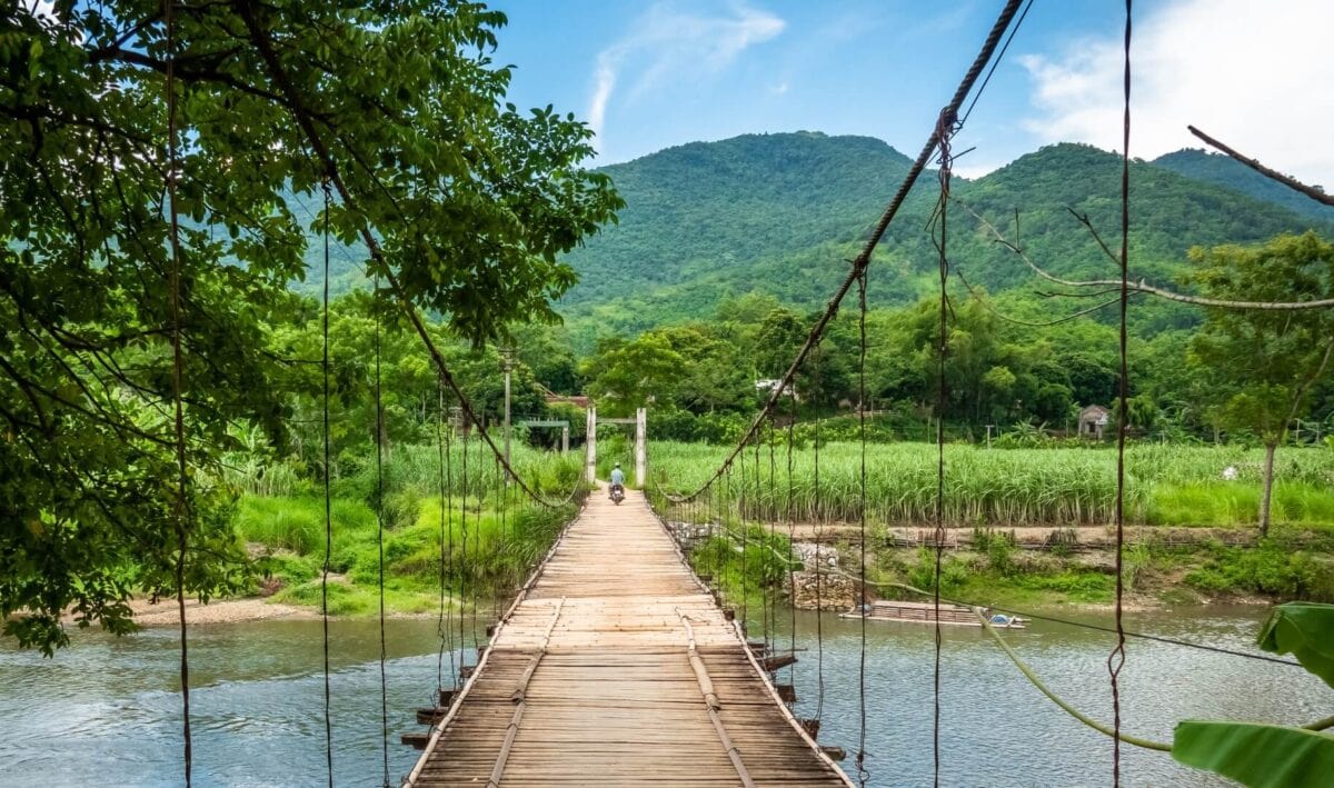 Wiszący most w Pu Luong prowadzący przez rzekę w kierunku zielonych gór północnego Wietnamu.