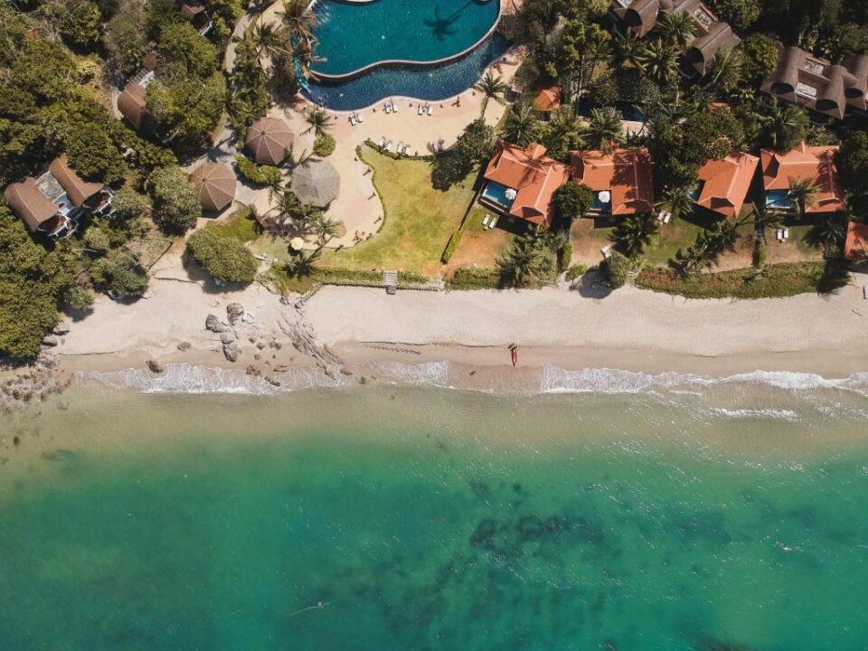 Widok z g&oacute;ry na Rawi Warin Resort & Spa na Koh Lancie z plażą i turkusową wodą.