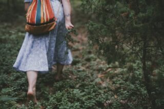 Uczestniczka wyprawy Atma Joga na Warmii podczas zielarskiego spaceru boso wśród leśnej ścieżki.