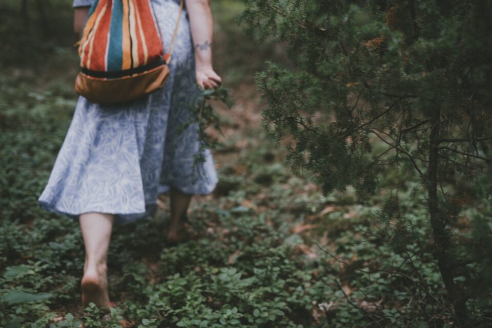 Uczestniczka wyprawy Atma Joga na Warmii podczas zielarskiego spaceru boso wśród leśnej ścieżki.