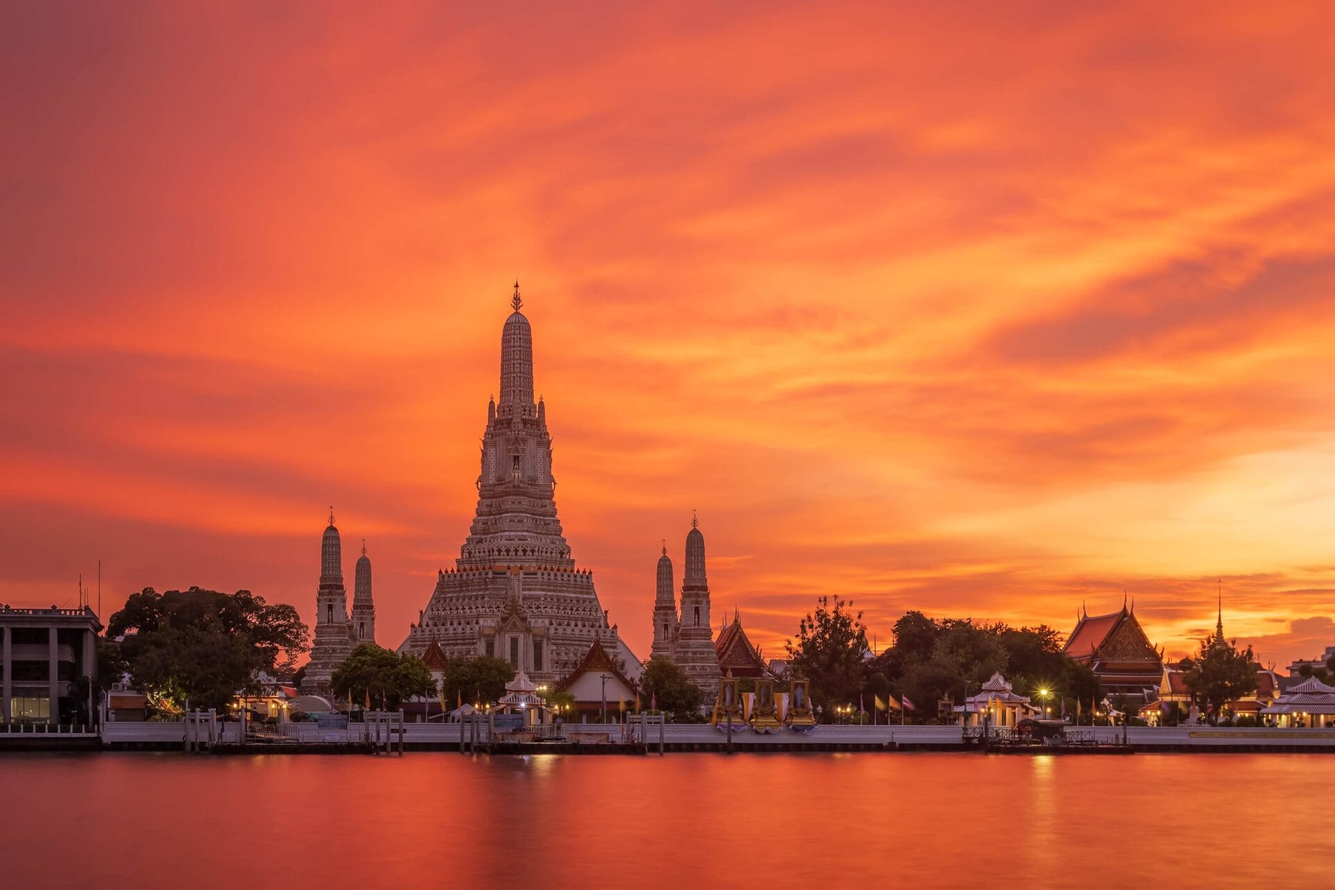 Świątynia Wat Arun o zachodzie słońca nad rzeką w Bangkoku.