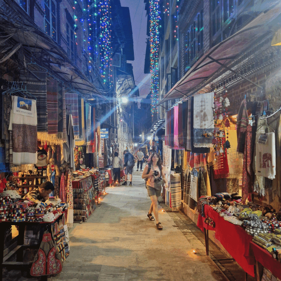 Tętniąca życiem ulica handlowa w dzielnicy Thamel w Katmandu, Nepal, z lokalnymi sklepami i hotelami, idealna do zwiedzania po trekkingu w Dolinie Langtang.