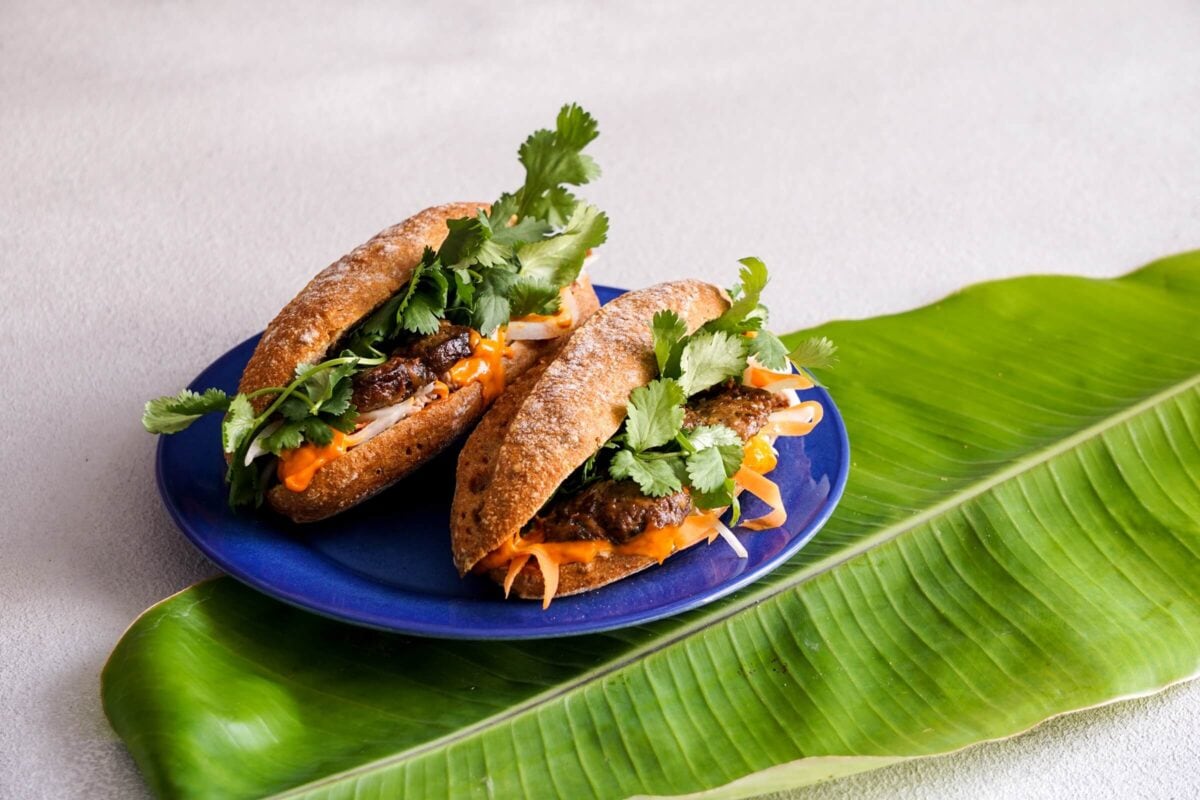 Wietnamskie banh mi podane na liściu bananowca – tradycyjna kanapka z świeżymi ziołami.