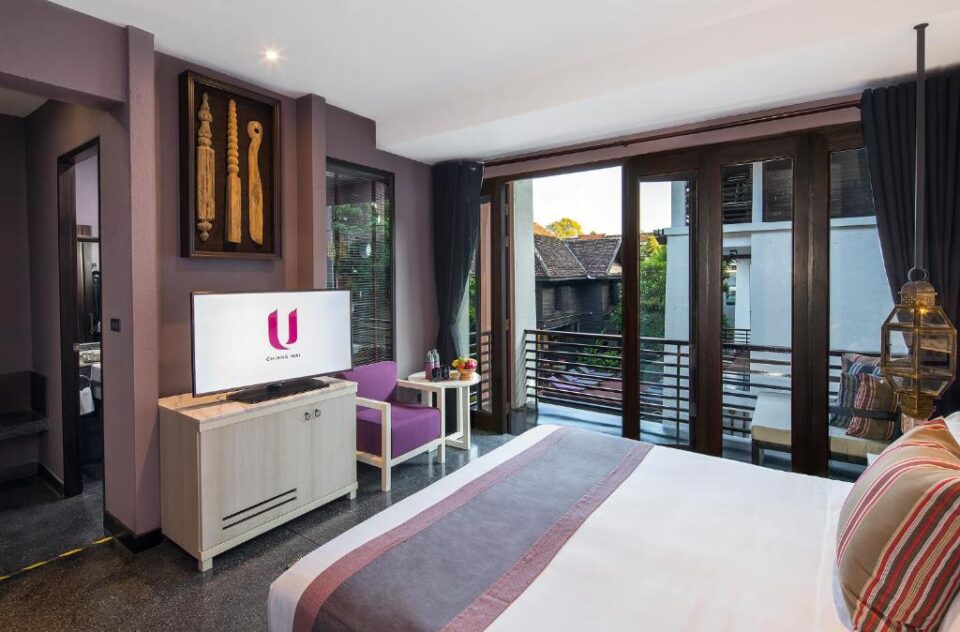 Nowoczesny pok&oacute;j hotelowy w U Chiang Mai z balkonem i widokiem na patio.