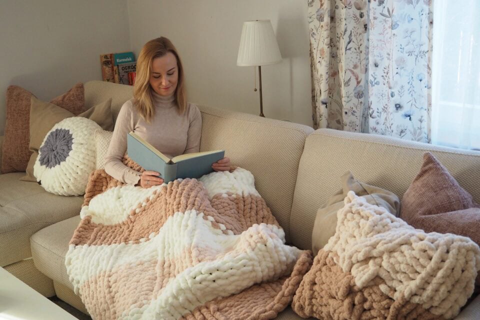 Uczestniczka wyprawy Atma Joga odpoczywa po warsztatach rękodzieła, owinięta własnoręcznie dzierganym kocem.