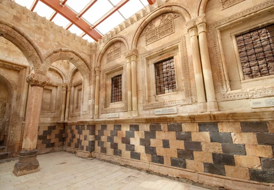 Wnętrze Pałacu Ishaka Paszy – kamienne arkady i wzorzyste posadzki w rezydencji osmańsko-perskiej w Dogubayazit, Turcja